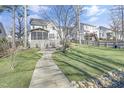 Enjoy a sprawling backyard featuring a stone walkway, mature trees, and fire pit at 1600 Patterson Grove Rd, Apex, NC 27502