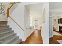 Bright and airy foyer features hardwood floors, carpeted stairs, and view to living spaces at 1600 Patterson Grove Rd, Apex, NC 27502