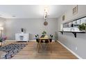 Elegant dining room with modern table setting and a pass-through to the updated kitchen at 174 St. Andrews Ln, Chapel Hill, NC 27517