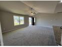 Bright living room featuring neutral walls, carpeted floors, a ceiling fan, and natural light from a window at 197 Pate Landing Dr, Selma, NC 27576