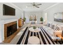 Bright living room with a brick fireplace, a ceiling fan, and neutral colors at 4016 Ridgebrook Bluffs Dr, Raleigh, NC 27603