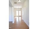 Bright hallway featuring hardwood floors and a view into a room with a chandelier and double doors at 410 Henry Cir, Sanford, NC 27330