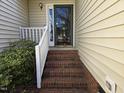 Close-up of the front entrance, featuring brick steps, storm door and well-maintained landscaping at 4300 Mantua Way, Raleigh, NC 27604