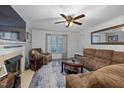 Cozy living room with a fireplace, comfortable seating, and a ceiling fan at 5108 Walton Hill Rd, Knightdale, NC 27545