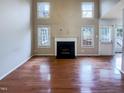 Spacious living room featuring hardwood floors, fireplace, and large windows at 5317 Tifton Dr, Raleigh, NC 27610