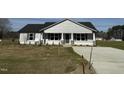 Inviting home exterior with stone accents and a covered entrance, surrounded by newly planted landscaping at 57 Faucette Dr, Selma, NC 27576