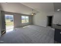 Spacious living room featuring plush carpet, a modern ceiling fan, and bright windows, creating a cozy atmosphere at 57 Faucette Dr, Selma, NC 27576