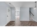 Hallway features stylish herringbone floors, leading to stairs and a bright entry door at 605 Stratton Way, Durham, NC 27704