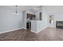 Open-concept living area featuring a fireplace, herringbone floors, and modern light fixture at 605 Stratton Way, Durham, NC 27704