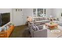 Bright, staged living room with large window and neutral tones at 623 Sybil Dr, Durham, NC 27703
