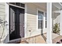 Close-up of the front door and covered porch with brick base and stylish accents at 6623 Academic Ave, Raleigh, NC 27616