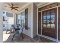 Inviting front porch with stone steps, cozy seating area, and stylish entry door at 7025 Dayton Ridge Dr, Apex, NC 27539