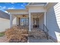 Inviting front porch with stone steps, cozy seating area, and stylish entry door at 7025 Dayton Ridge Dr, Apex, NC 27539
