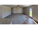 Living room boasts plush carpeting, a ceiling fan, an open layout and seamless transition to the kitchen at 90 Pate Landing Dr, Selma, NC 27576