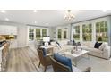 Bright open-plan living room with hardwood floors, large windows, and a cozy seating area at 206 Faith Ave, Sanford, NC 27330