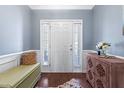 Welcoming foyer featuring a white front door with sidelights, wood floors, and decorative accents at 107 Vickery Hill Ct, Durham, NC 27703