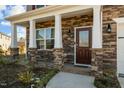 Inviting front porch with stone columns and charming front door at 110 Lodgepole Ln, Burlington, NC 27215
