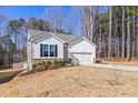 Charming one story home featuring an inviting curb appeal with a side view of the attached two-car garage at 138 Clear Water Rd, Louisburg, NC 27549