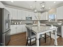 Modern kitchen featuring white cabinets, stainless steel appliances, and a granite island at 140 Southern Acres Dr, Fuquay Varina, NC 27526