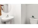 Modern half bathroom featuring pedestal sink, updated faucet, and efficient toilet at 231 Perseus St, Angier, NC 27501