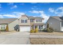 Beautifully landscaped two-story home with stone and siding, a two-car garage, and a welcoming entrance at 2437 Cedar Rock Dr, Wake Forest, NC 27587