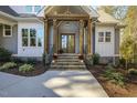 Inviting front entrance with wooden pillars, brick steps, and decorative pumpkins at 25 Blackhorn Ct, Pittsboro, NC 27312