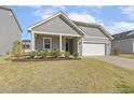 Charming single-story home with gray siding, white trim, a manicured lawn, and an attached two-car garage at 3333 Sandy Meadows Dr, Fuquay Varina, NC 27526
