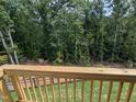 An inviting balcony view with wooden railing overlooking lush greenery and trees in the backyard at 4506 Mint Leaf Ln, Raleigh, NC 27612