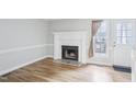 Bright living room with hardwood floors and a cozy fireplace with white mantle and gray tile at 4523 Hamptonshire Dr, Raleigh, NC 27613