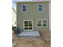 Exterior home view showcases a green vinyl siding, and a gray concrete patio with a sliding glass door entrance at 46 Shay St, Angier, NC 27501