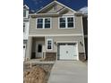 Charming townhome with a one-car garage, neutral siding, and stone accents on the facade at 52 Shay St, Angier, NC 27501