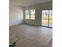 Bright living room with large windows and sliding glass doors leading to a patio area at 52 Shay St, Angier, NC 27501