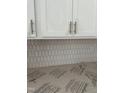 Close-up of kitchen backsplash and cabinets, featuring a unique tile design and modern hardware at 58 Shay St, Angier, NC 27501
