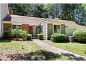 Charming single-story home with a brick facade, landscaped yard, and inviting walkway at 5840 Branchwood Rd, Raleigh, NC 27609