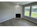 Cozy living room featuring a fireplace, hardwood floors, and lots of natural light at 82 Asher Pointe Way, Benson, NC 27504