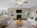 Bright living room with a fireplace and lots of windows at 95 Cinnamon Teal Way, Youngsville, NC 27596
