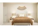 Neutral bedroom featuring a comfortable bed, side tables with lamps, and charming wall decor at 1006 Sora Way, Durham, NC 27703