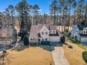 Aerial view of a two-story home with a manicured lawn, driveway and a surrounding of tall trees at 104 E Seve Ct, Morrisville, NC 27560