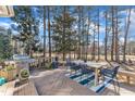 Outdoor deck with a stainless steel grill, wooden table, blue chairs and a manicured backyard at 104 E Seve Ct, Morrisville, NC 27560