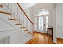 Elegant foyer with hardwood floors, a decorative front door, and a staircase with white spindles at 109 Coffeeberry Ct, Garner, NC 27529