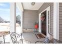 Covered front porch featuring stylish décor, a cozy seating area, and an inviting entrance at 127 Lakemont Dr, Clayton, NC 27520