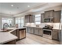 Well-lit kitchen with gray cabinets, stainless steel appliances, and white countertops at 129 Oban Dr, Homesite 150, Sanford, NC 27330