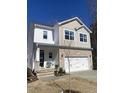 Well-maintained two-story home with stone accents, a covered front porch, and a two-car garage at 13 Piccadilly Ct, Durham, NC 27713