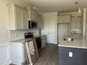 Well-lit kitchen featuring gray cabinets, an island, and stainless steel appliances at 143 Prency Ln, Middlesex, NC 27557