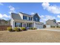 Attractive two-story home with a manicured lawn, a covered porch, and an attached garage at 149 Minter School Rd, Sanford, NC 27332