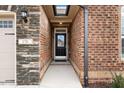 Close-up of the front door with stone and brick architecture and a well-lit entrance at 170 Dunvegan Ln, Burlington, NC 27215