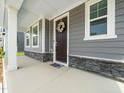 Welcoming front porch with stone accents, a decorative wreath, and ample space at 1981 Rosedale Ridge Ave, Wake Forest, NC 27587
