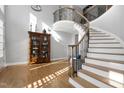 Elegant foyer featuring a curved staircase with iron railings and hardwood floors at 2110 Crigan Bluff Dr, Cary, NC 27513