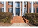 Inviting brick steps lead to a grand entrance with black double doors and elegant architectural details at 2110 Crigan Bluff Dr, Cary, NC 27513
