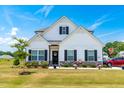 Charming two-story home featuring a well-manicured lawn and inviting front porch with decorative plants at 23 Tullamore Ln, Four Oaks, NC 27524